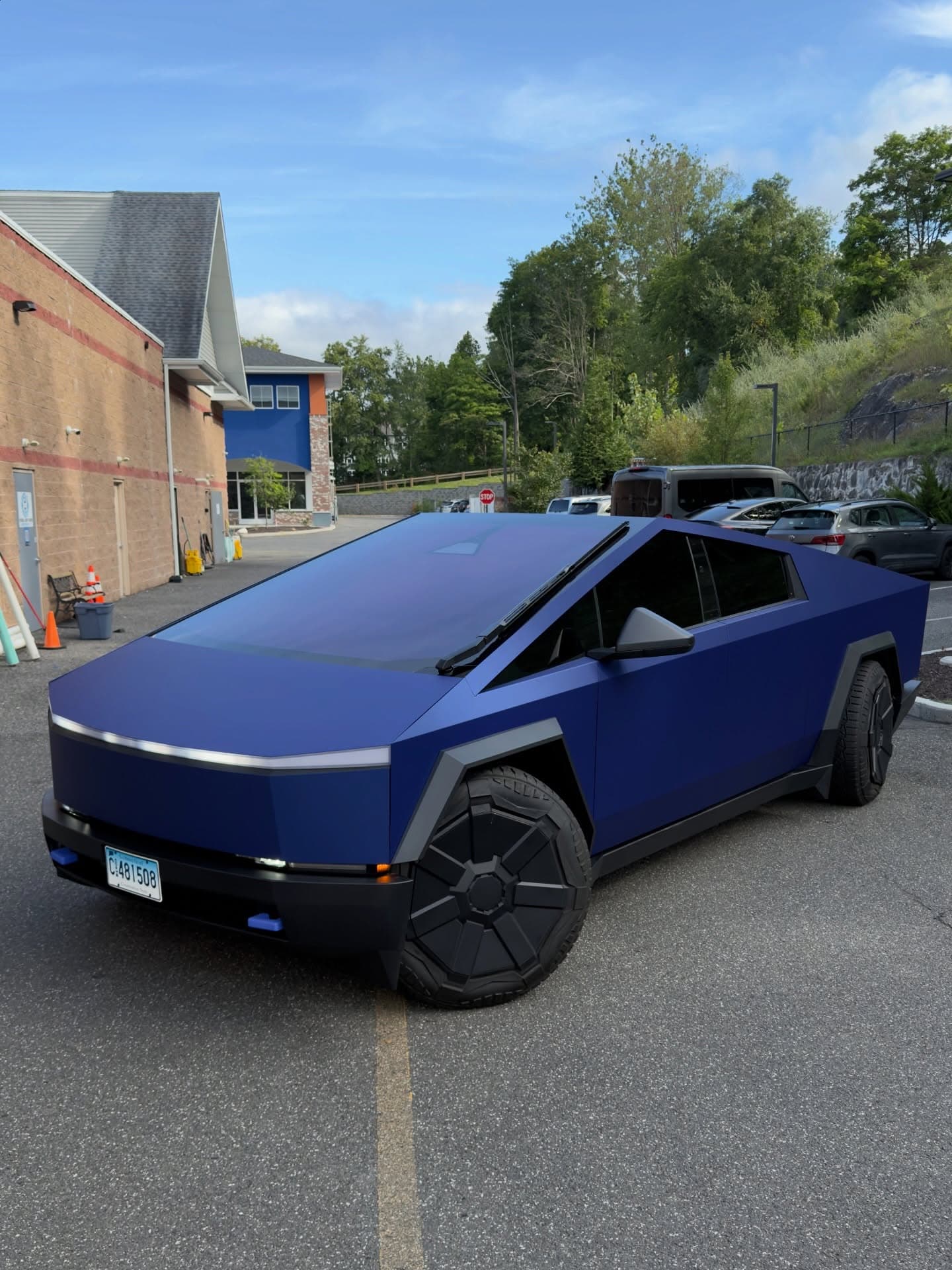Deep-blue Tesla Cybertruck parked outdoors under a clear sky.